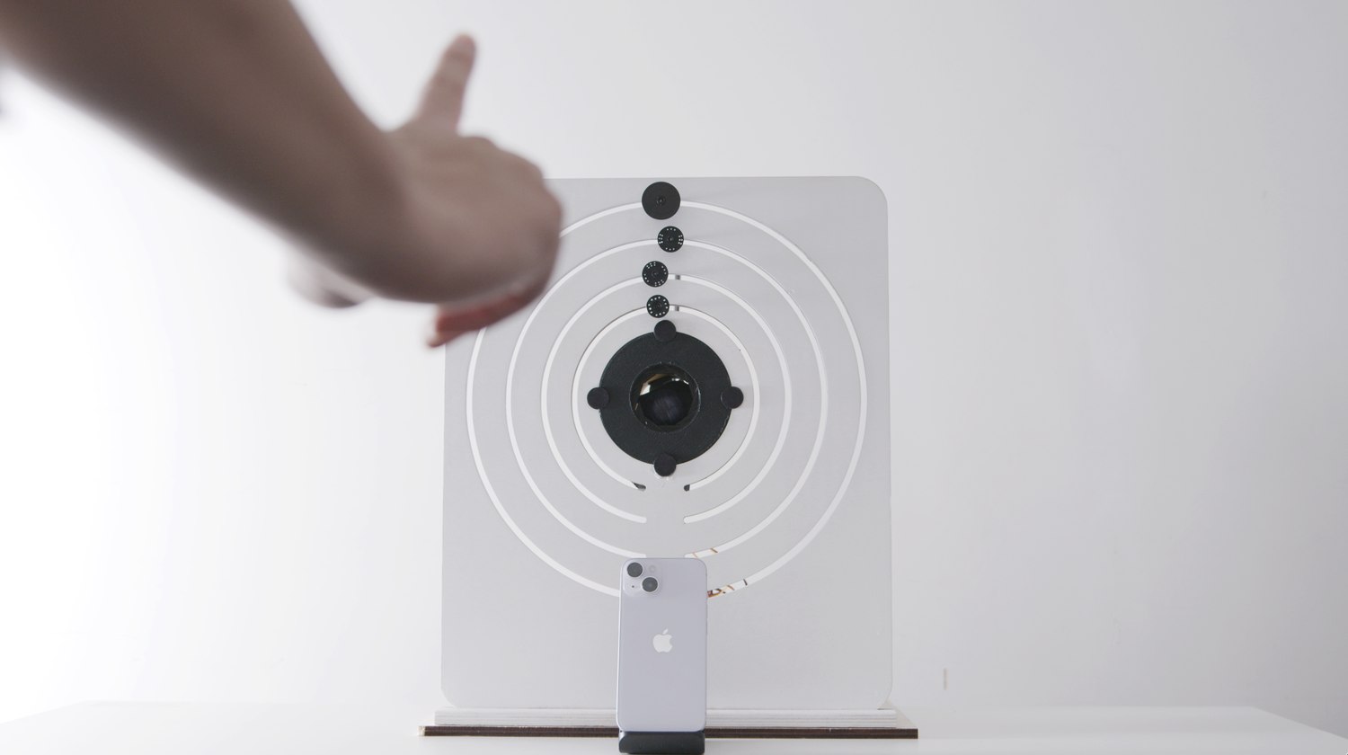 A hand held in front of the device with one finger extended, the corresponding ring turned to its position