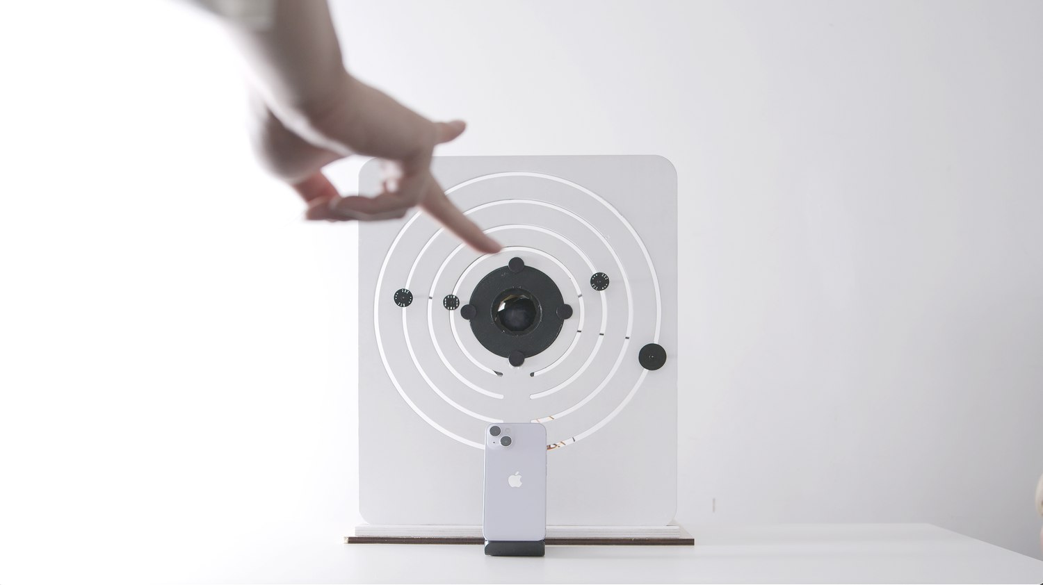 A hand pointing towards the device with markers moved to a new position on the rings