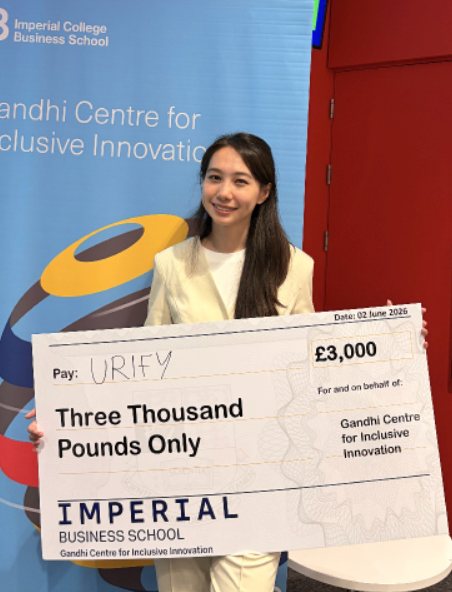 Yidan holding a three thousand pound cheque from the Imperial Business School Gandhi Centre for Inclusive Innovation, made out to Urify