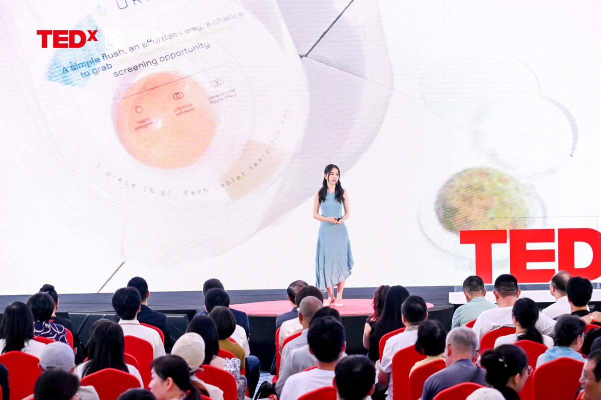 Yidan on a TEDx stage presenting Urify