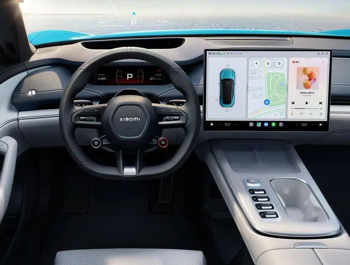 The SU7 interior: a wide landscape centre screen on the dashboard, a slim driver's display behind the wheel, and almost no physical controls